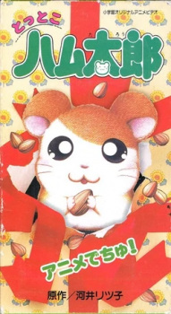 Okładka Tottoko Hamtarou Anime Dechu z Hamtaro wyskakującym z czerwonego pudełka wśród ziaren słonecznika